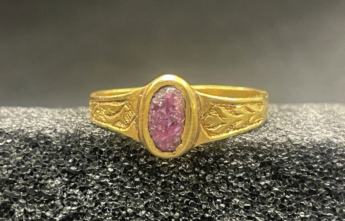 Photo of a gold ring with a pink oval-shaped stone