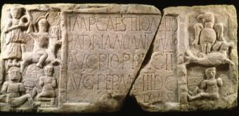 Photo of a Roman distance slab with Latin inscribed in the centre and carved figures on the edge