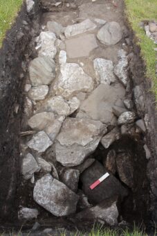 An open trench showing the Bronze Age structures - the photographic scale is on the roof of the subterranean corbelled structure, surrounded by a paved area