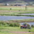 People on a tractor with large standing stones in the background