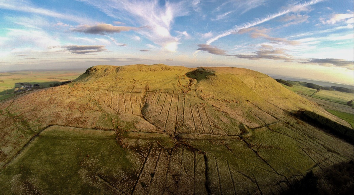 Aerial view of a rural landscape with a hill