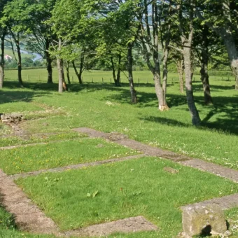 Photo of the ground-level remains of a Roma-era building in a field