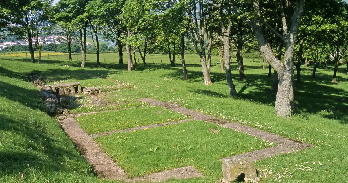 Photo of the ground-level remains of a Roma-era building in a field