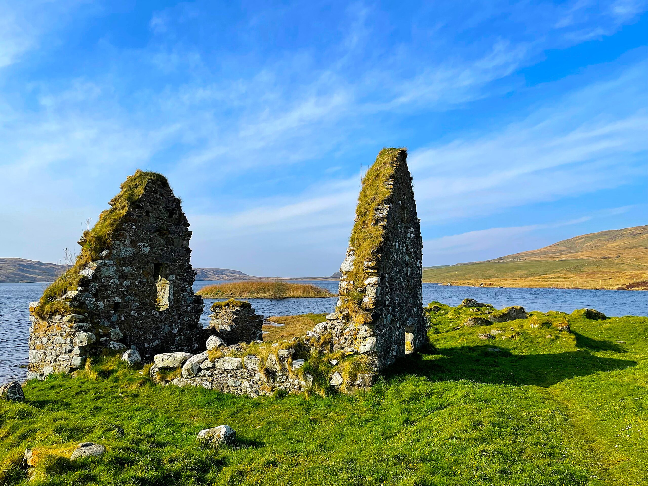Photo of the stone ruins of a house on an island in a loch
