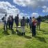 People in outdoor clothing standing around a prehistoric monument