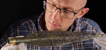 Person looking at ancient spearhead