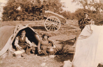Black and white photo of a Gypsy/Traveller family and their wagons