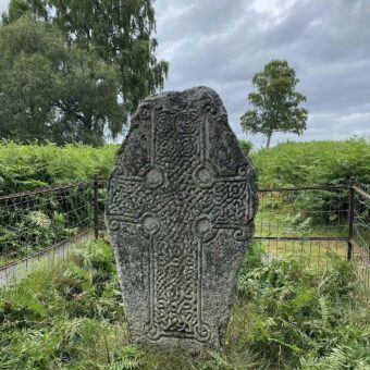 The Kinord Cross is a Class III Pictish cross slab located in the Muir of Dinnet National Nature Reserve. Dating from the later Pictish period, the stone features an ornate, interlace-filled cross that dominates its surface. The cross has three equal-length, square-ended arms, with spirals at each corner and circular hollows in the angles between the arms, all linked by a ring. Uniquely, the spirals at the base of the shaft are double, while the others are single.