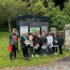 Photo of a group of people standing outside of a park and smiling
