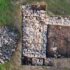 Aerial drone shot of an open archaeological trench showing stone walls