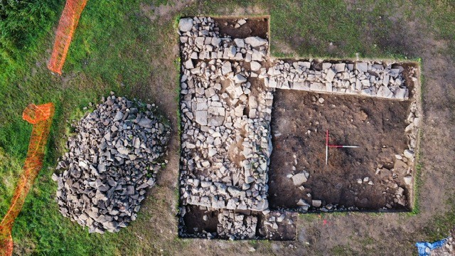 Aerial drone shot of an open archaeological trench showing stone walls