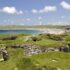 Photo of the earthwork remains of a Neolithic village by the sea